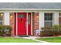 Close-up of the red brick home's entrance, highlighting the vibrant red front door and detailed brickwork at 407 Westchester Dr, Altamonte Springs, FL 32701