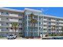 Exterior building view showing multiple floors, balconies, palm trees, and parking at 4153 S Atlantic Ave # 2120, New Smyrna Beach, FL 32169