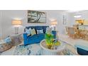 Bright living room featuring beach-themed decor, a comfortable blue sofa, and stylish furniture at 4153 S Atlantic Ave # 2120, New Smyrna Beach, FL 32169