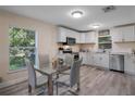 Bright kitchen boasts white cabinets, modern appliances, and a dining area with hardwood floors at 500 W Oakland Ave, Oakland, FL 34760