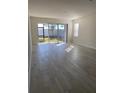 Airy living room featuring neutral walls, tile floors, and sliding glass doors opening to the outside at 605 Big Pine Ave, Minneola, FL 34715