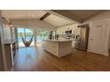 Sunlit kitchen with island, stainless steel appliances, and pantry offers modern convenience at 6428 Lynn Rd, Orlando, FL 32810