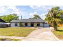 Charming single-story home featuring lush landscaping and a welcoming front porch at 765 Coachlight Dr, Casselberry, FL 32730