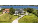 Aerial view of a waterfront property with manicured grounds, brick driveway and a lake view at 7706 Ficquette Rd, Windermere, FL 34786