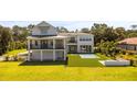 Spacious backyard featuring an in-ground pool, manicured lawn, a covered patio and an outdoor firepit at 7706 Ficquette Rd, Windermere, FL 34786