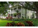 Two-story home featuring a well-manicured lawn with lush garden beds and mature trees at 8335 Lake Burden Circle, Windermere, FL 34786