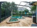 Screened-in pool area, complete with a spa, sun loungers and seating for relaxation and entertainment at 8335 Lake Burden Circle, Windermere, FL 34786