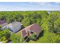 Aerial view of a charming home with lush surrounding trees and a peek of a lake at 848 Magnolia Creek Cir, Orlando, FL 32828