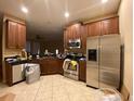 Modern kitchen with stainless steel appliances, granite countertops, and wood cabinets at 8608 Falstaff Pl, Oviedo, FL 32765