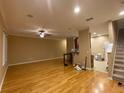 Spacious living room with hardwood floors, a ceiling fan, and an open view of the kitchen at 8608 Falstaff Pl, Oviedo, FL 32765