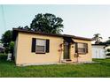View of a single story home with green lawn, rock landscaping and black shutters at 920 Timor Ave, Orlando, FL 32804