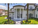 Home's impressive front entrance is framed by majestic columns, complemented by lush landscaping and a winding walkway at 9259 Tibet Pointe Cir, Windermere, FL 34786