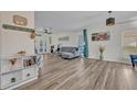 Bright living room featuring wood-look floors, neutral walls, a stylish gray sofa, and backyard views at 9455 Belmont Ter, Oviedo, FL 32765