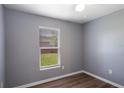 Bedroom with wood-look flooring, gray walls, and a window at 1002 S Locust Ave, Sanford, FL 32771
