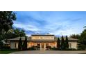 Elegant exterior of a home with landscaped grounds, featuring a circular driveway and beautiful architectural lighting at 1112 Preserve Point Dr, Winter Park, FL 32789