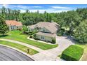 Beautiful single-story home showcasing a well-manicured lawn, lush landscaping, and a brick driveway at 11602 Graces Way, Clermont, FL 34711