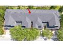Overhead view of townhome roofs, displaying a complex layout and mature trees, marked with a red arrow at 14231 Desert Haven St # Ge, Windermere, FL 34786