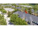 Aerial view of a townhome complex with well-maintained roofs and landscaping, highlighted with a red arrow at 14231 Desert Haven St # Ge, Windermere, FL 34786