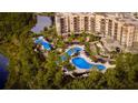 Aerial view showcasing resort-style pools, lush landscaping, and lakefront condos at 14501 Grove Resort Ave # 2440, Winter Garden, FL 34787