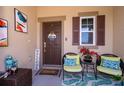 Inviting front porch with seating area, decorative welcome sign, and stylish decor, offering a cozy and welcoming entrance at 16379 Blooming Cherry Dr, Groveland, FL 34736