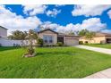 Charming home with a green lawn and manicured landscaping. It has a neutral color palette and a two car garage at 16379 Blooming Cherry Dr, Groveland, FL 34736
