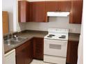 Functional kitchen featuring wooden cabinets, a white electric range, and neutral countertops at 1827 Blaine Ter, Winter Park, FL 32792