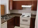 Functional kitchen with wood cabinets, a white range, and a double stainless steel sink at 1827 Blaine Ter, Winter Park, FL 32792