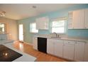 Bright kitchen featuring white cabinetry, black appliances, and wood floors at 1975 Waldo St, Orlando, FL 32806