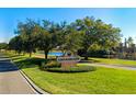 Scenic entrance to Crossroads community featuring lush landscaping and a serene lake backdrop at 202 Ferryboat Ct, Orlando, FL 32828