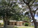 Charming single-story home featuring a well-manicured front yard with mature trees at 2023 Messina Ave, Orlando, FL 32811