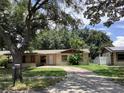 Single-story home featuring a front yard with mature trees and landscaping at 2023 Messina Ave, Orlando, FL 32811