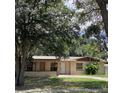 Charming single-story home featuring a well-manicured front yard with mature trees and beautiful landscaping at 2023 Messina Ave, Orlando, FL 32811