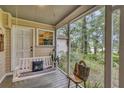 Cozy screened-in porch featuring a porch swing, creating a relaxing outdoor living space at 2132 Palm Vista Dr, Apopka, FL 32712