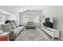 Bright living room features neutral decor, two sofas, two windows, and a modern entertainment center at 240 Cambridge Blvd, Winter Park, FL 32789