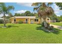 Inviting single-Gathering home featuring lush green lawn and mature palms at 2704 Yule Tree Dr, Edgewater, FL 32141