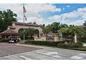 Welcoming entrance to Lake Pineloch Village with lush landscaping, flags, and a manned guard house at 2928 Lake Pineloch Blvd # Ge, Orlando, FL 32806