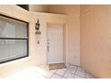 Inviting front door with tile flooring and a security light, creating a secure and welcoming entrance at 2928 Lake Pineloch Blvd # Ge, Orlando, FL 32806