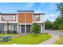 Modern townhome showcasing a well-maintained lawn and contemporary architectural design at 3301 Tranquil Trl, Kissimmee, FL 34747