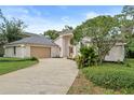 Beautiful home exterior features an attached garage, well-manicured lawn, and architectural pillars at 388 Hampton Hills Ct, Debary, FL 32713