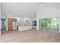 Bright living room with vaulted ceilings, hardwood floors, and a seamless open-concept design to the kitchen at 388 Hampton Hills Ct, Debary, FL 32713