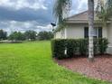 Exterior view showcasing the home's backyard with well-kept lawn and mature trees in the distance at 4034 Bougainvillea Pl, Kissimmee, FL 34746