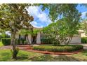 Well-maintained front yard with lush landscaping and mature trees framing a cozy, single-story residence at 4034 Bougainvillea Pl, Kissimmee, FL 34746