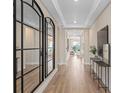 Bright hallway features modern wood floors, mirrors, decor, and trim details on the ceiling at 4116 Winding Pines Dr, Apopka, FL 32712