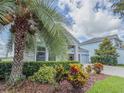 View of the home with stone accents, lush landscaping, and a three-car garage at 4632 Egg Harbor Dr, Kissimmee, FL 34746