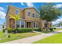View of a charming two-story residence with stone facade, green shrubs, palm tree, and neat landscaping at 5217 Creekside Park Ave, Orlando, FL 32811
