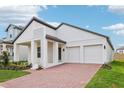Beautiful single-Gathering home showcasing modern architecture, a two-car garage and a brick driveway at 5308 Citrus Leaf Blvd, Winter Garden, FL 34787