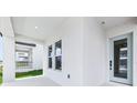 View of the front porch featuring a modern door, windows, and a glimpse of neighborhood at 5308 Citrus Leaf Blvd, Winter Garden, FL 34787