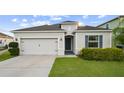 Inviting single-story home with a manicured lawn and two-car garage, featuring a welcoming entrance at 622 Taft Dr, Davenport, FL 33837