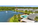 Aerial view showcasing community pool and surrounding townhomes along a scenic lake at 6462 S Goldenrod Rd # 31B, Orlando, FL 32822