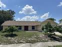 Lovely single-story house with attached two-car garage, well-kept lawn, and inviting red door, under sunny sky at 6610 Pampus Dr, Orlando, FL 32819